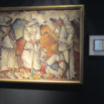 A painting depicting four women wearing all white and headscarves. Three are standing, one is crouched. Behind them are red mountains.